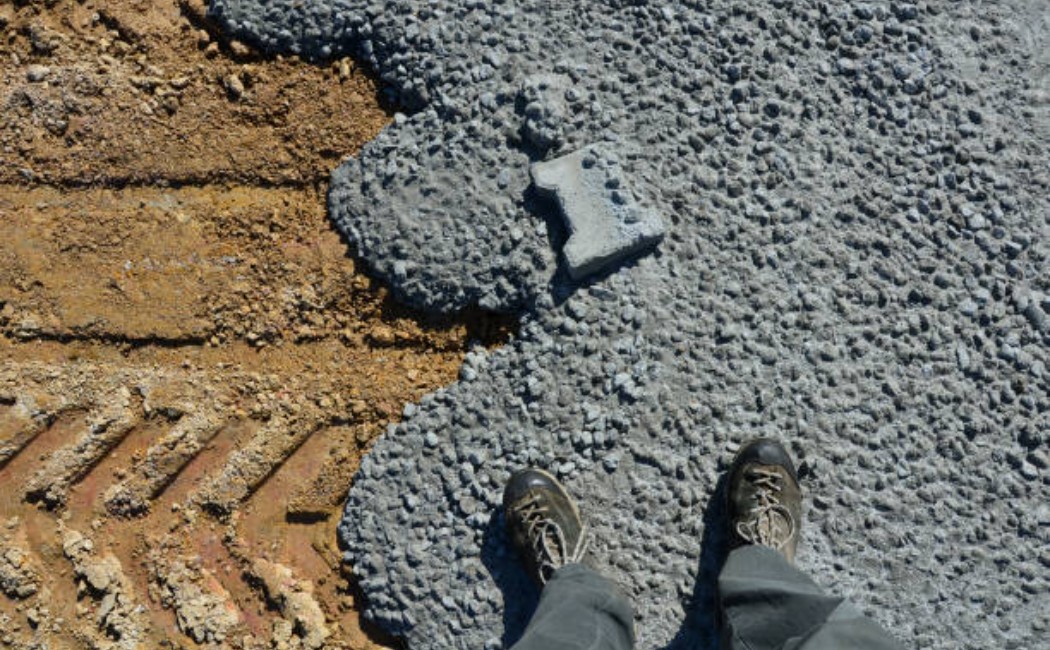 Dry, hardened concrete poured and left over a patio of interlocking pavers