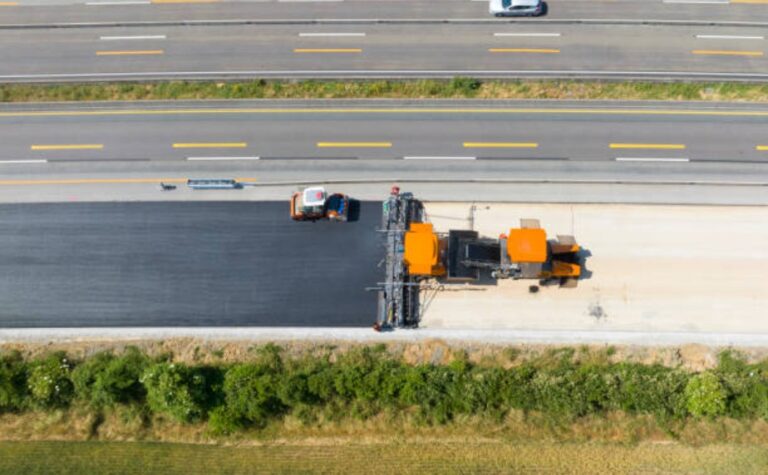 Aerial view of road construction during asphalt paving services on a highway.