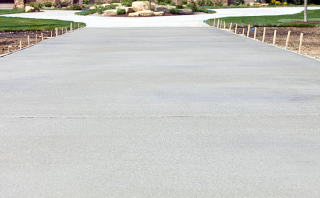 New concrete driveway leading to a modern luxury house