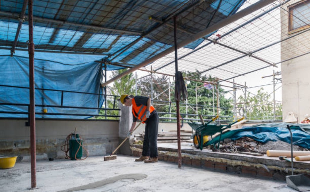Roofer inspecting the bottom of a terrace roof structure.