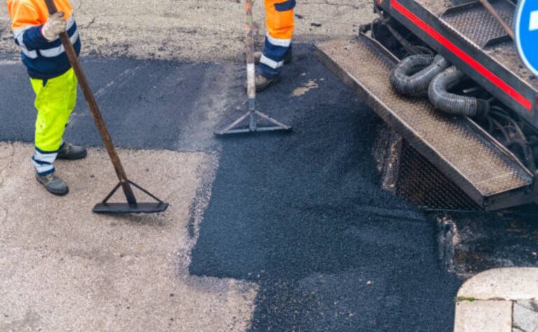 Worker managing an asphalt paving machine for road maintenance