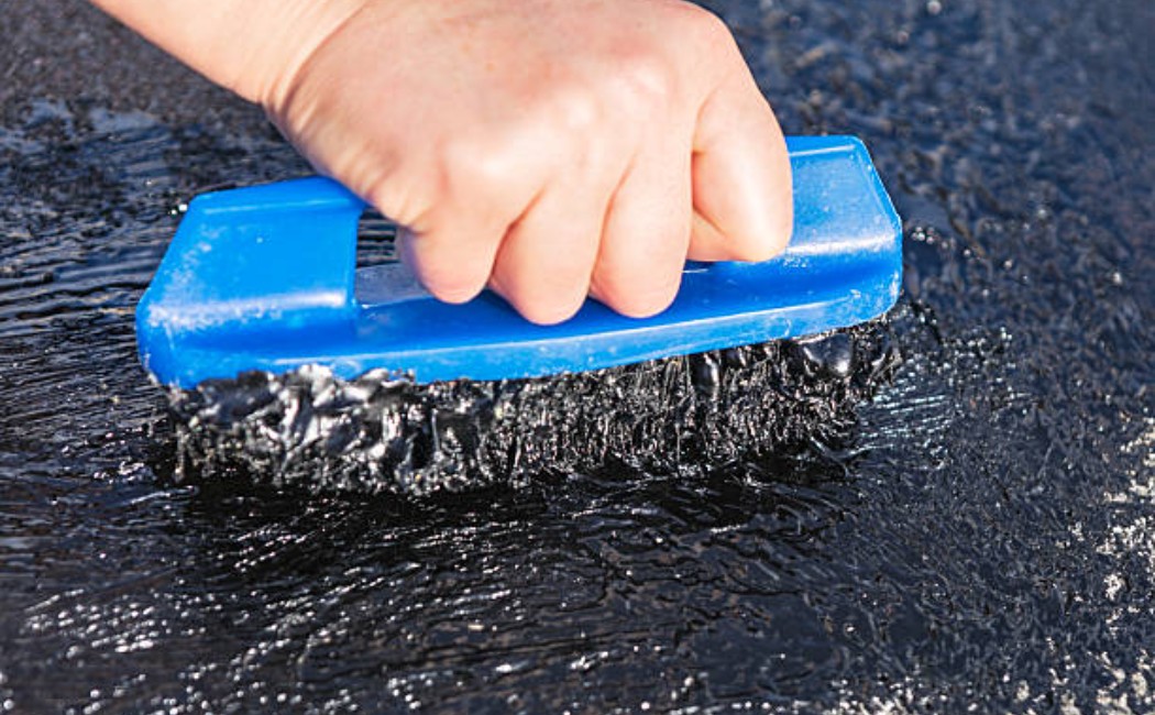 Tar application on residential roof during maintenance work
