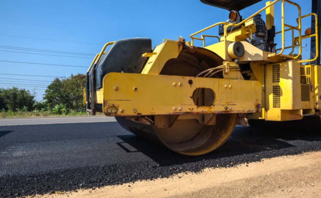 Asphalt paving process with a road roller machine in action.