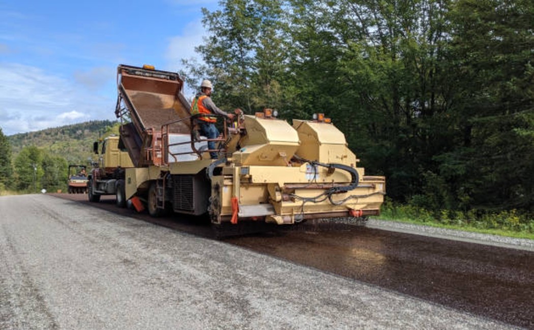 \Workers operating road surfacing machines on a rural highway