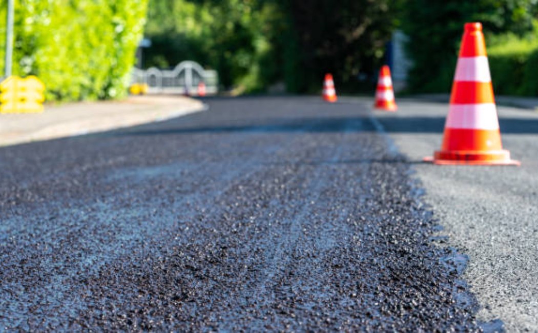 Road paving in progress with safety cones lined up