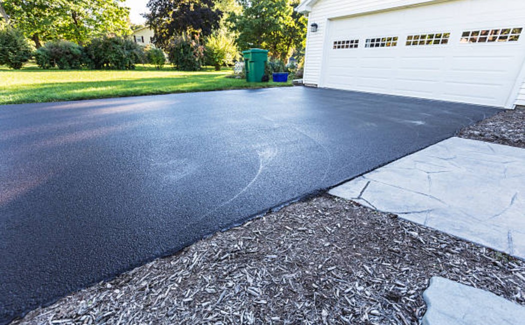 Tar and chip driveway surface with fresh asphalt aggregate stones