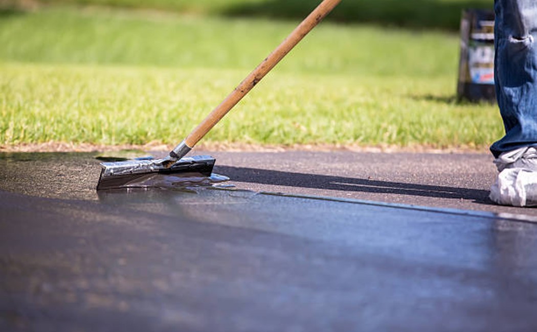 Seal coating driveway with brush close-up