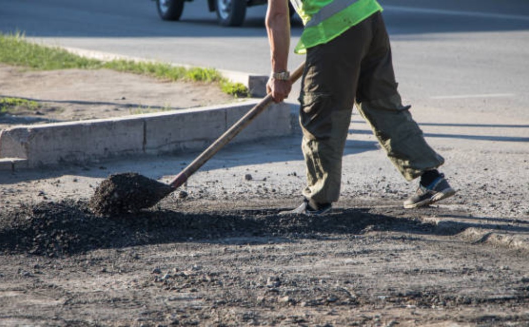 Street repair team resurfacing the asphalt road.