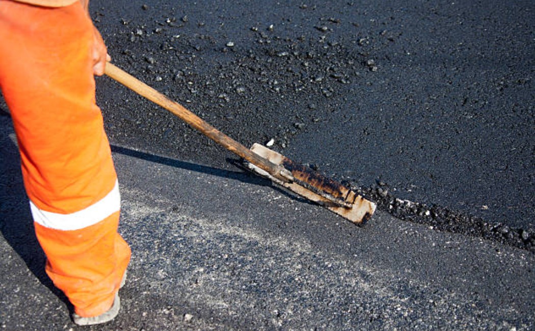 Fresh asphalt being laid on a road surface
