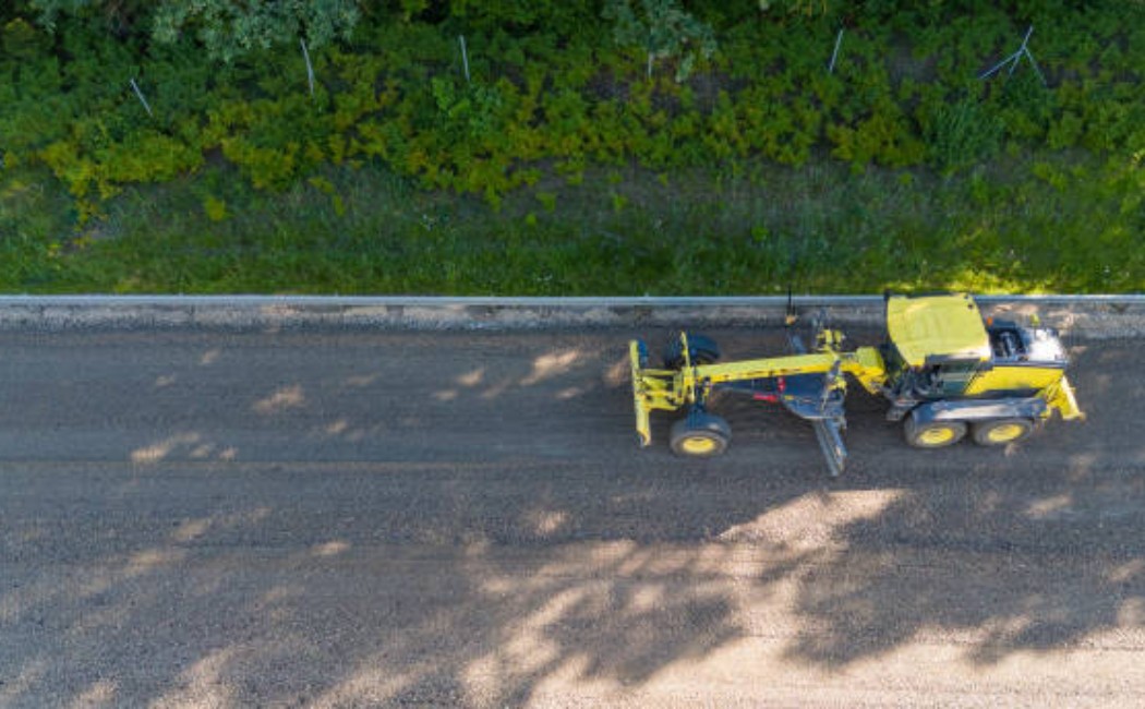 A long forest road seen from the sky with endless green trees.