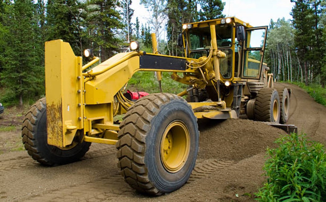 Road construction grader working on gravel road