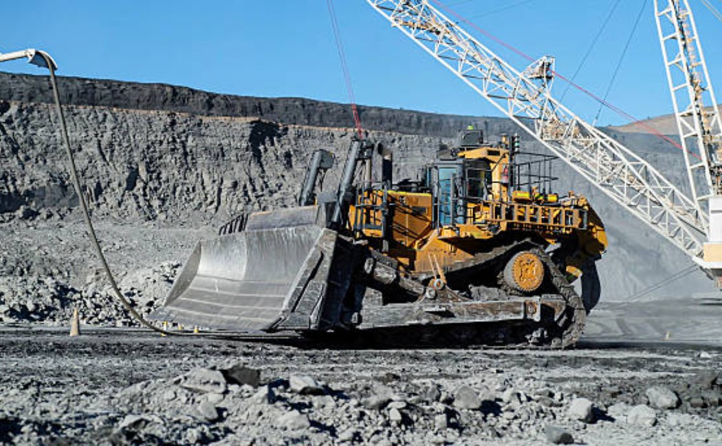 Massive construction dozer grading and spreading excavation material