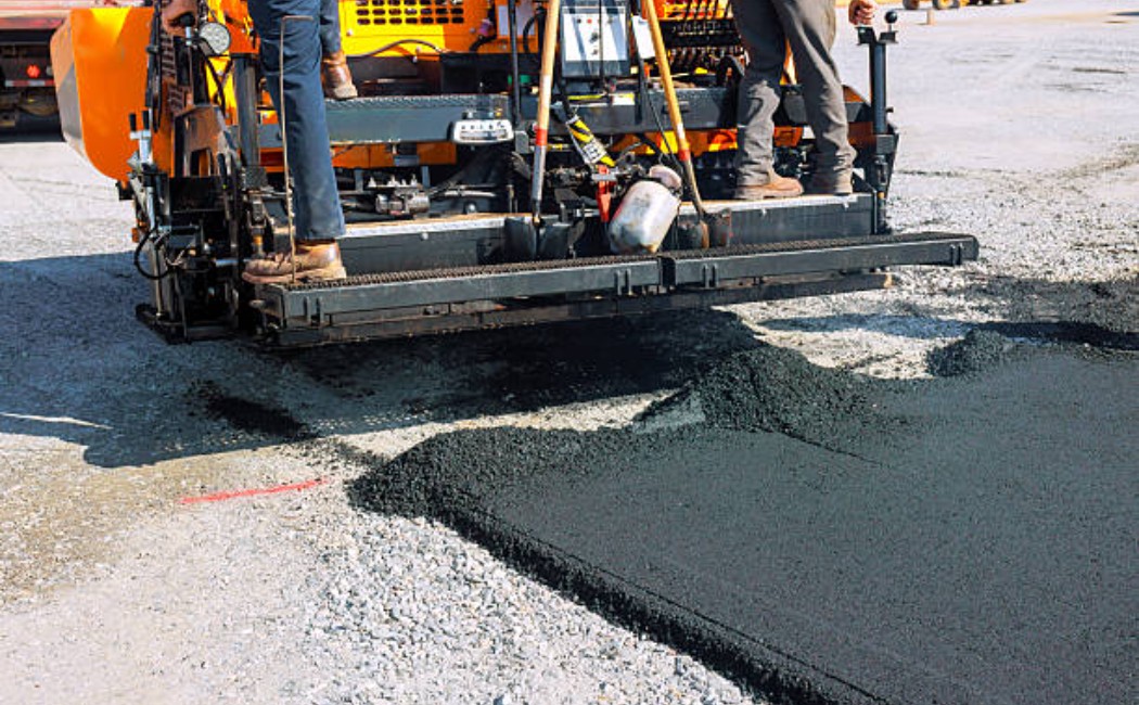 Asphalt paver preparing the road surface for traffic.