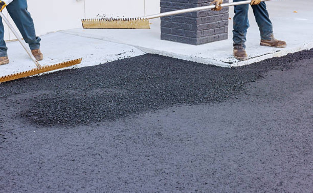 Workers laying new asphalt on the road in a commercial area
