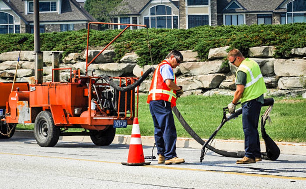 Road maintenance workers filling potholes on the highway