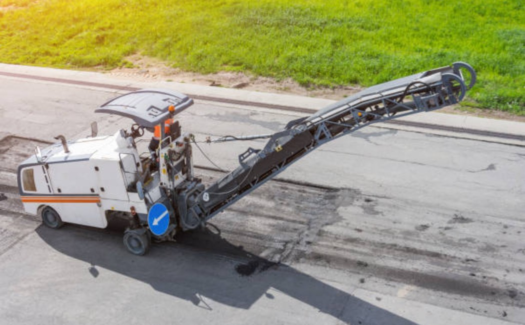 Road repair machine cutting old asphalt surface.