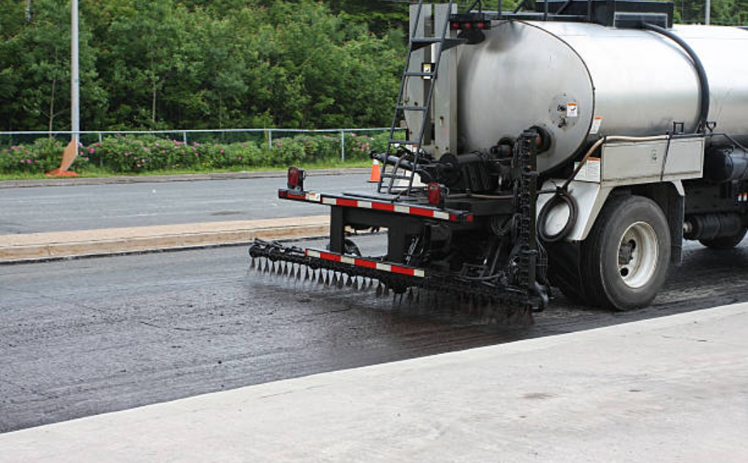 A tar truck applying asphalt on a road construction site