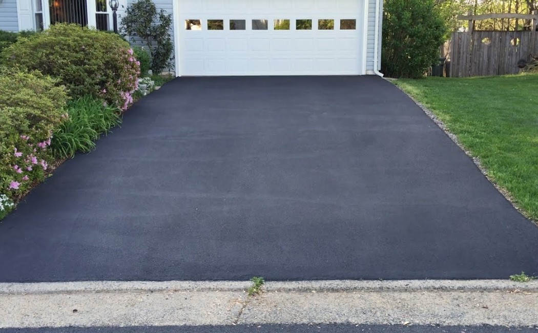 Freshly Paved Driveway Showcasing Professional Asphalt Resurfacing Freshly paved residential driveway with smooth black surface demonstrating professional asphalt resurfacing.