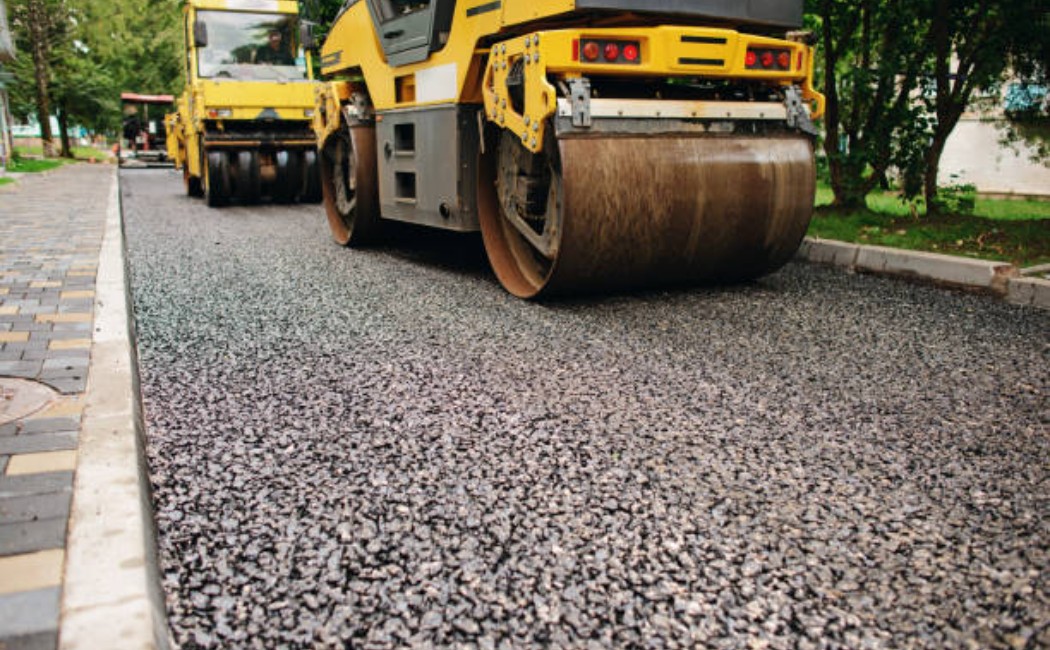 Road construction machine pressing hot asphalt pavement