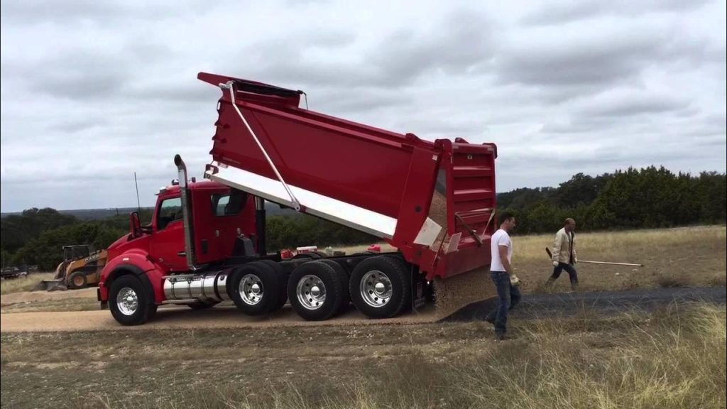 Tar and Chip Seal installation with aggregate spreading, creating a durable, weather-resistant roadway built to last.
