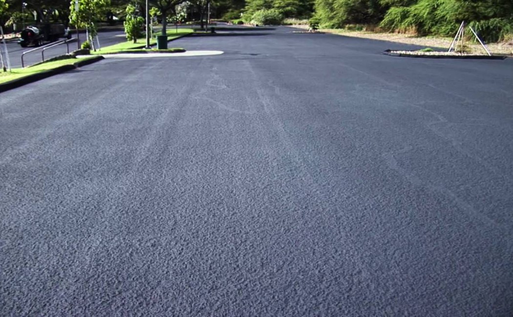 Parking Lot Asphalt Seal Coating Protection. Freshly completed asphalt seal coating on a large parking lot provides a smooth, uniform surface with enhanced protection and curb appeal.