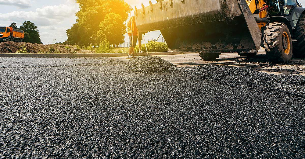 Fresh Asphalt Paving being installed with heavy construction equipment.