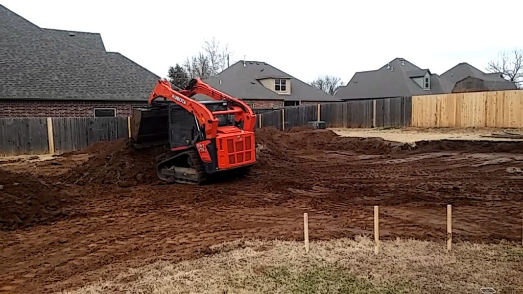 Grading Services using a compact excavator to level and prepare a residential construction site.
