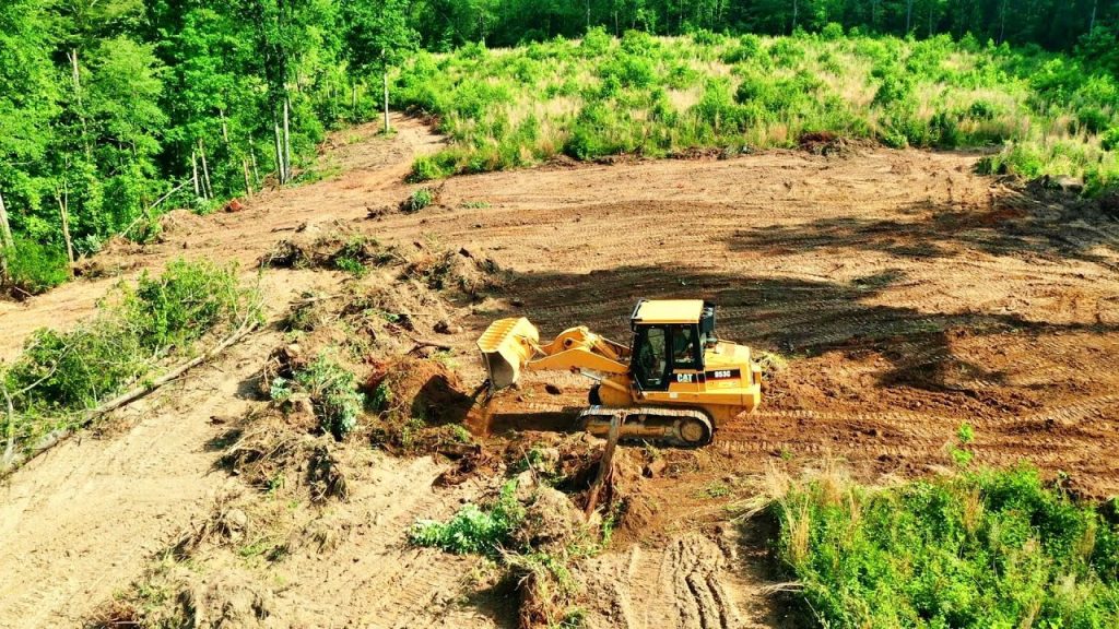 Grading Services using a heavy-duty excavator to efficiently level and prepare a cleared construction site.