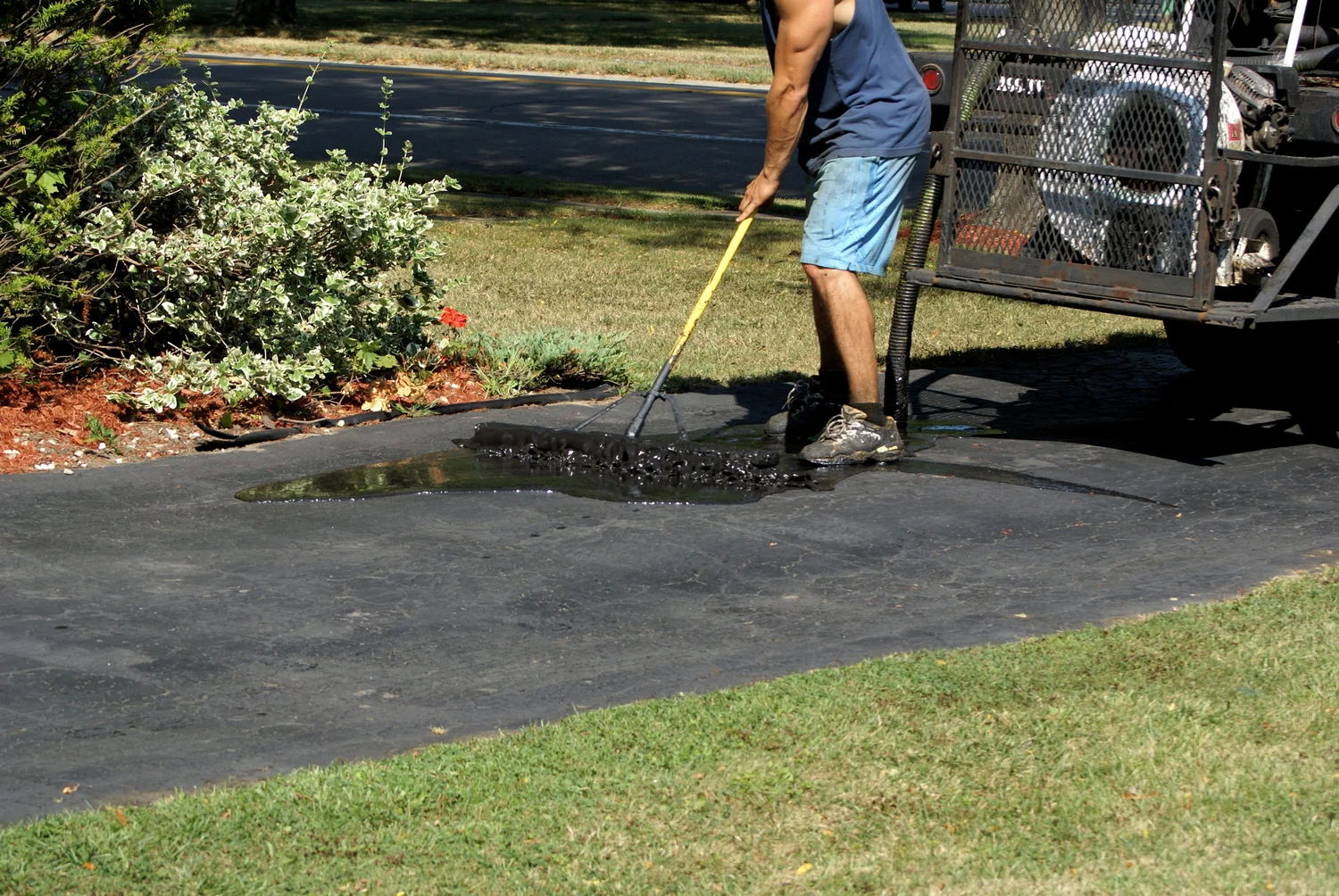 Seal Coating Services applying a smooth asphalt coating to restore driveway appearance and improve surface durability.