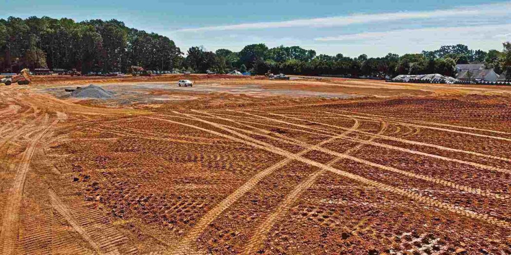 Grading Services preparing a large construction site with leveled ground and heavy equipment.