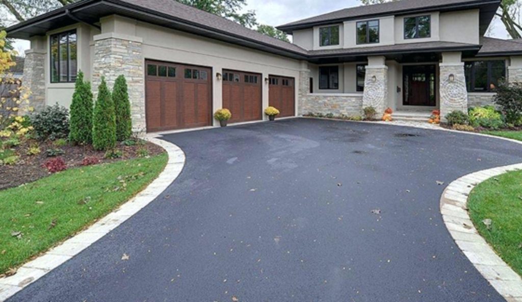 A beautifully sealed asphalt driveway enhancing a home’s curb appeal with Driveway Sealing Services.