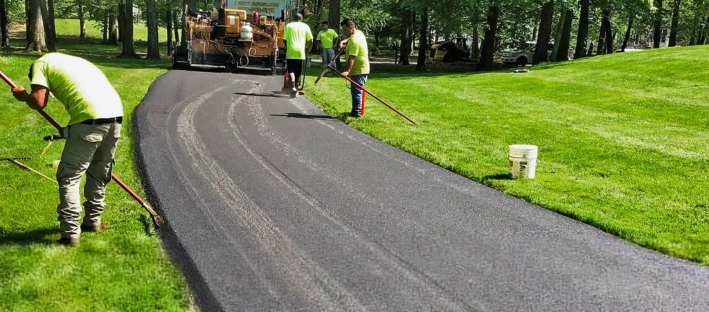 Asphalt maintenance crew paving a fresh driveway Asphalt Maintenance crew paving a smooth black driveway with fresh asphalt, creating a durable, attractive surface for a well-maintained property.